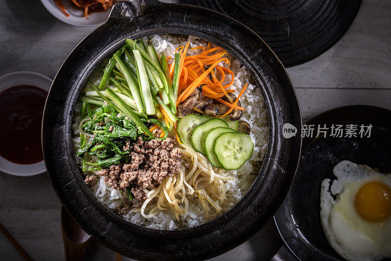 BI Bim Bap，拌菜饭，顶视图与热酱在铸铁锅